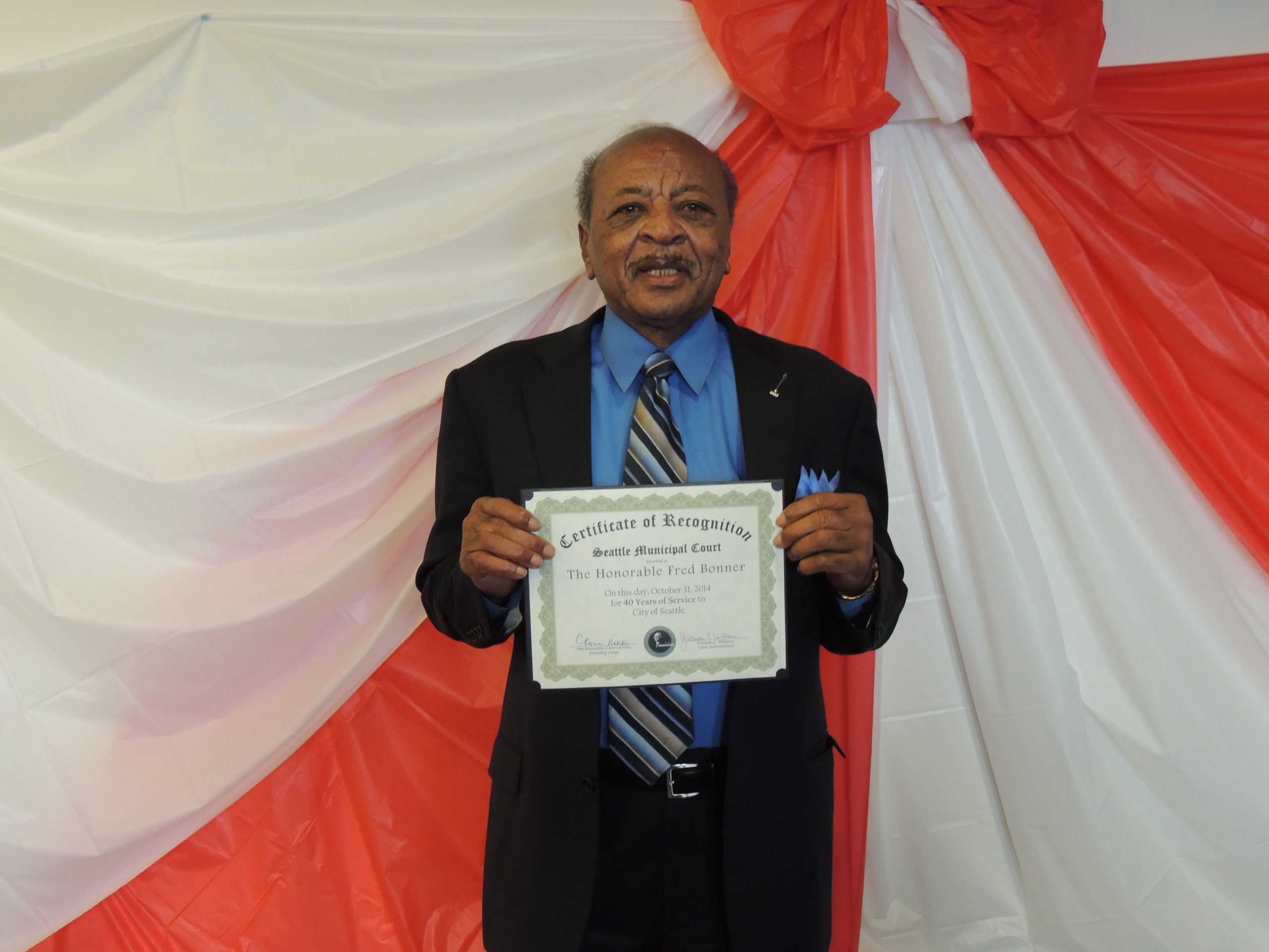 Judge Bonner smiling with his 40 years of service award certificate