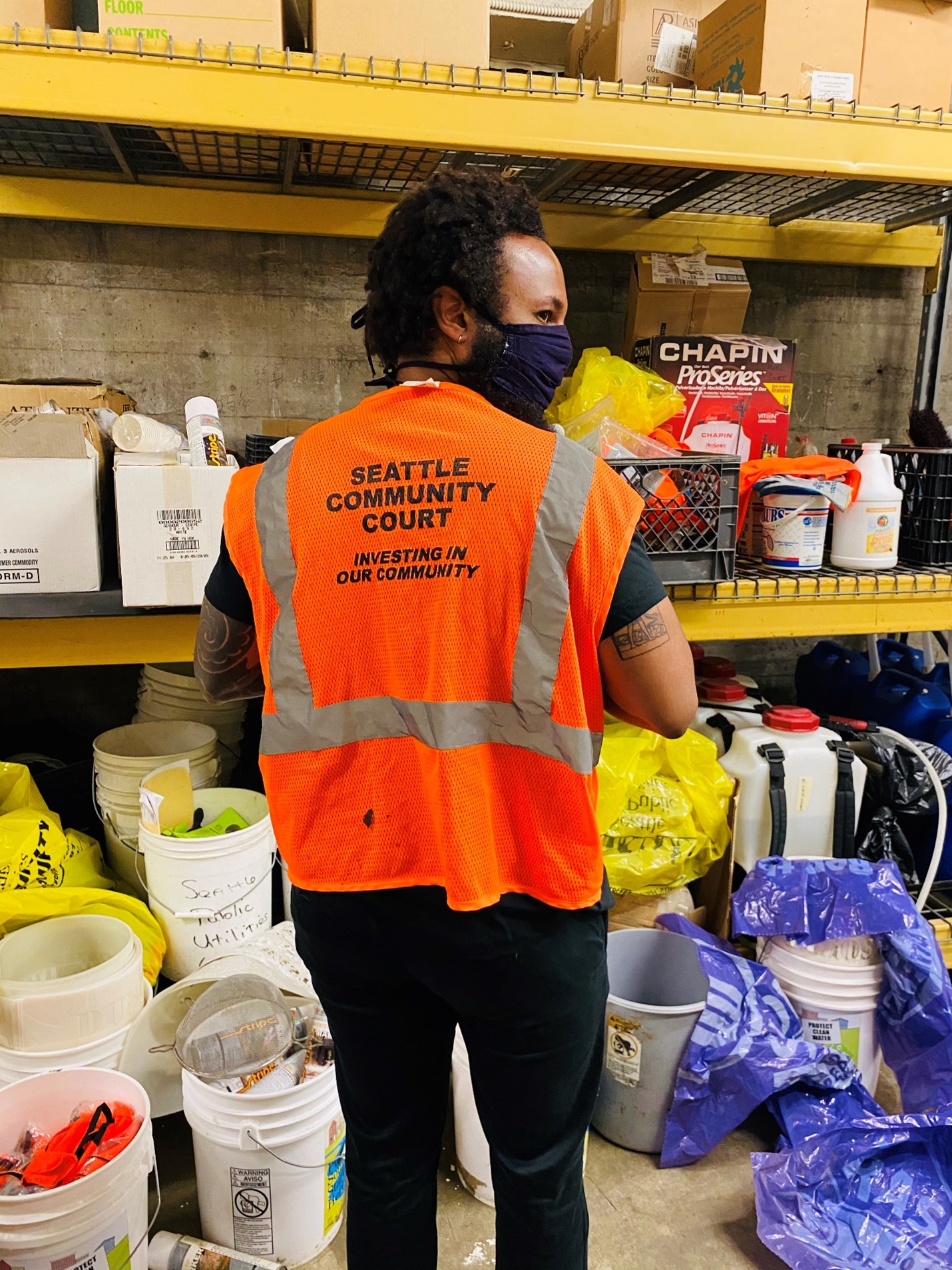 Curtis wearing an orange safety vest that says "Seattle Community Court: Investing in our Community" on the back